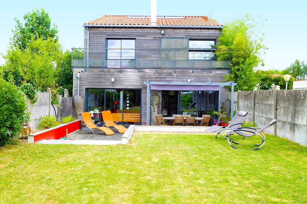 Inspiration pour une façade de maison grise design en bois de taille moyenne et à un étage avec un toit à deux pans.
