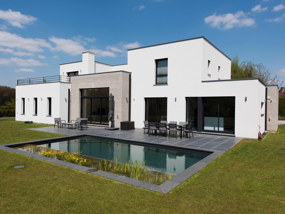 Diseño de fachada de casa blanca actual extra grande de dos plantas con tejado plano y revestimientos combinados