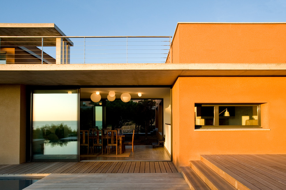 Свежая идея для дизайна: двухэтажный, оранжевый дом среднего размера в средиземноморском стиле с плоской крышей - отличное фото интерьера