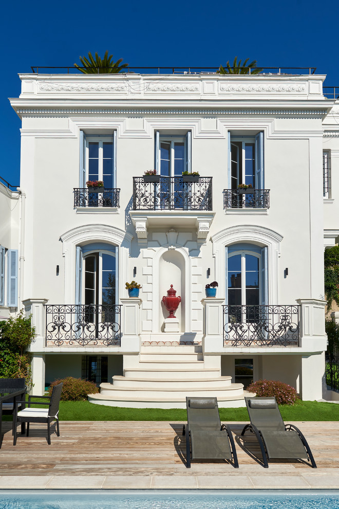 Ispirazione per la villa bianca mediterranea a tre piani con rivestimento in stucco, tetto piano e copertura verde