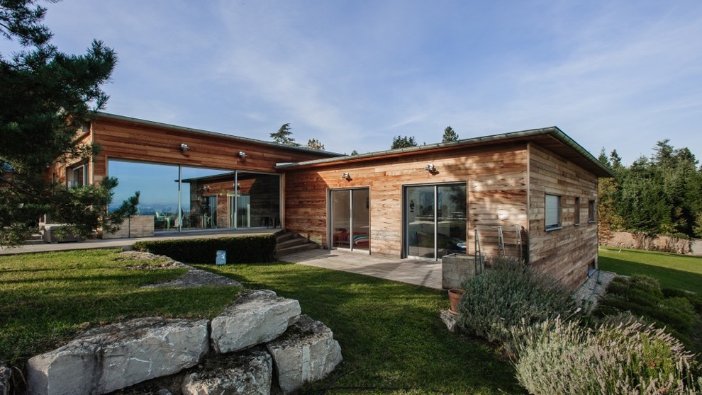 Mittelgroße, Einstöckige Moderne Holzfassade Haus mit brauner Fassadenfarbe und Walmdach in Sonstige