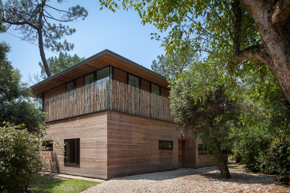 Diseño de fachada contemporánea de dos plantas con revestimiento de madera y tejado plano