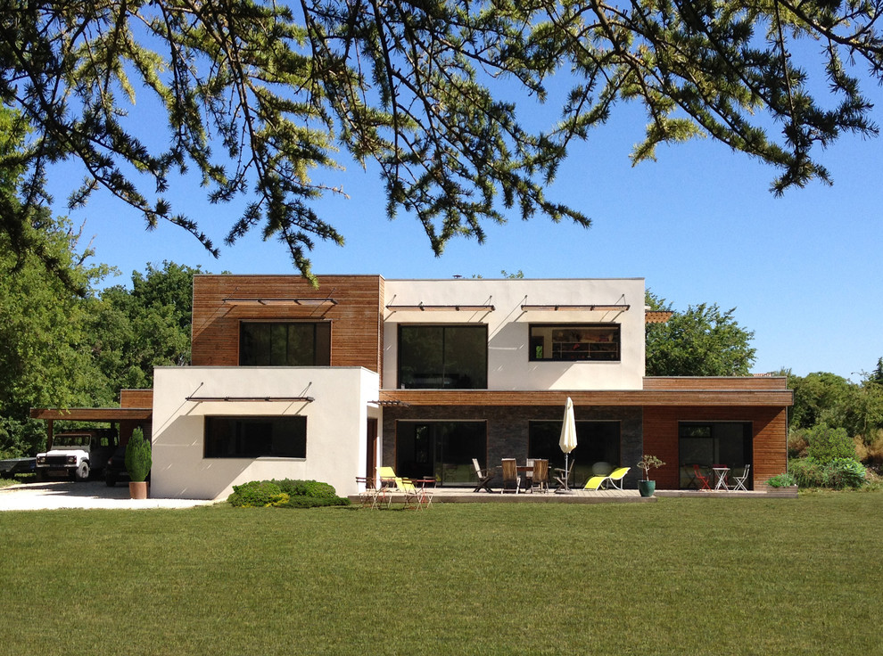 Foto de fachada de casa blanca actual de tamaño medio de dos plantas con revestimientos combinados, tejado plano y techo verde