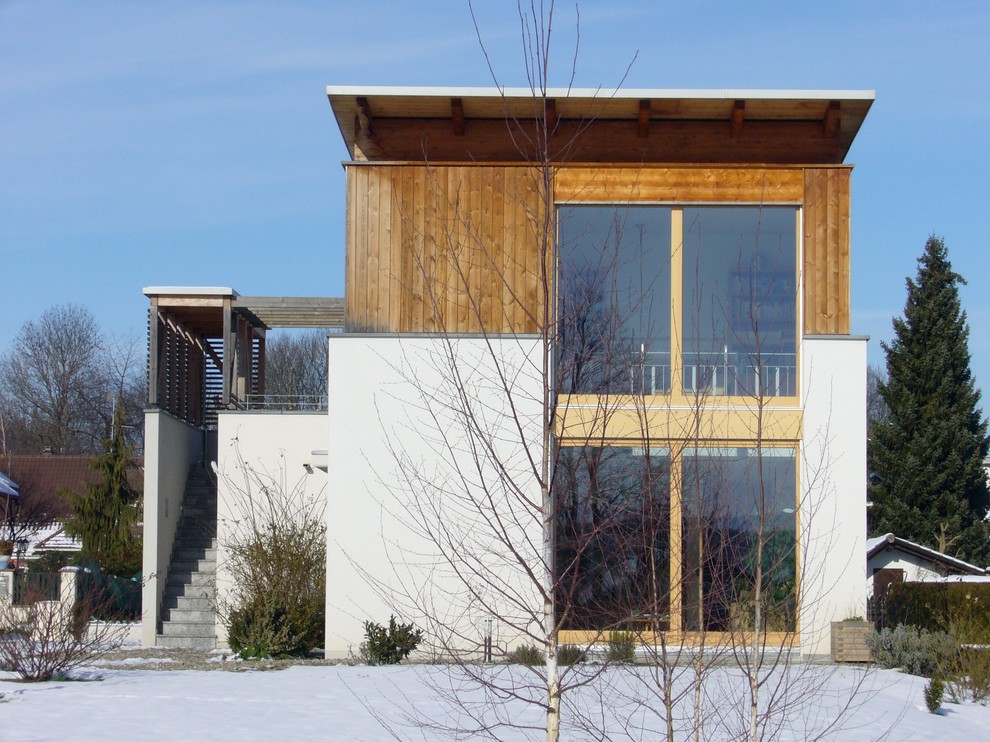 Aménagement d'une grande façade de maison blanche moderne en bois à un étage avec un toit plat.
