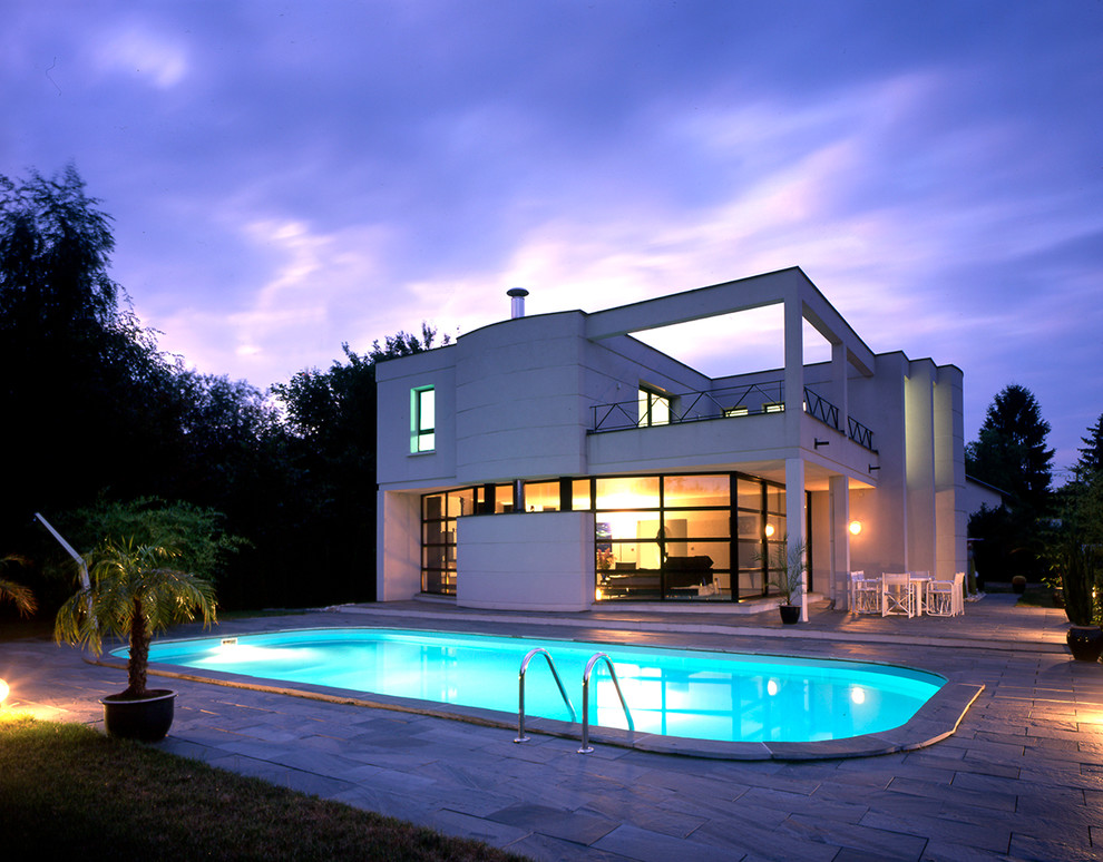Пример оригинального дизайна: большой, двухэтажный, белый дом в современном стиле с плоской крышей