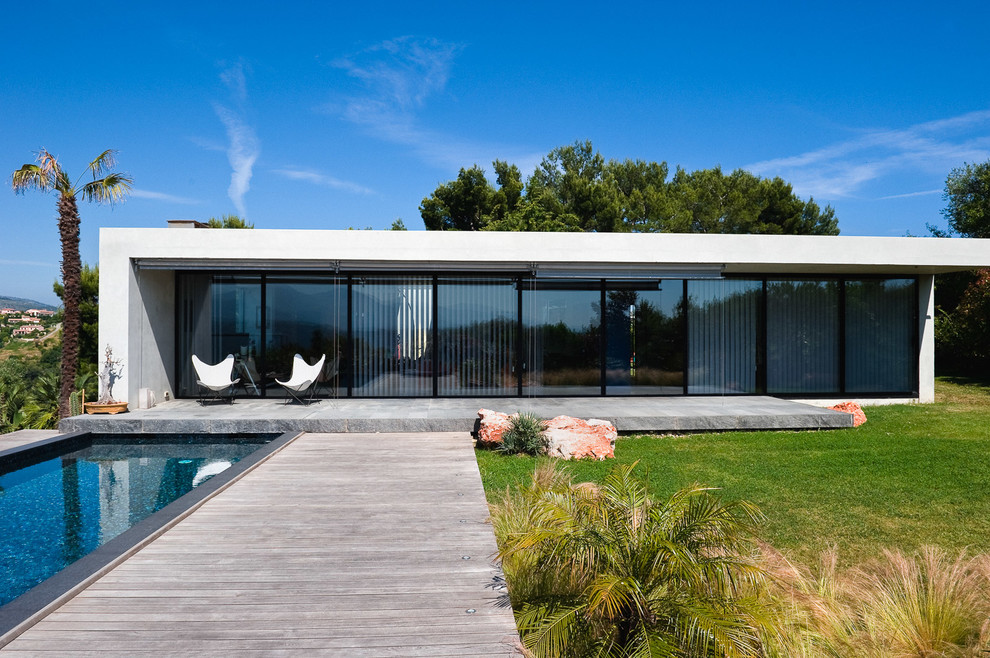 Idée de décoration pour une grande façade de petite villa blanche minimaliste en verre de plain-pied avec un toit plat.