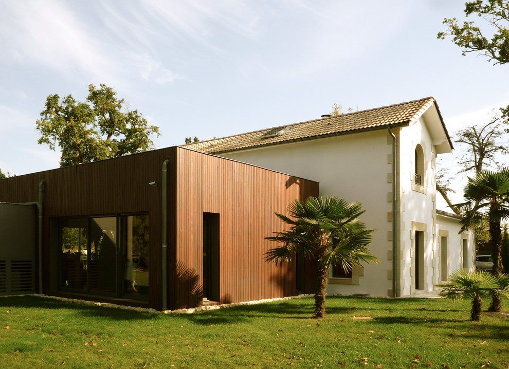 Cette image montre une façade de maison beige traditionnelle à un étage et de taille moyenne avec un revêtement mixte et un toit à deux pans.