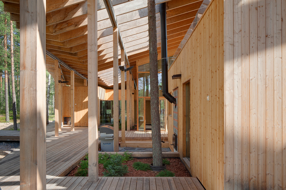 Idée de décoration pour une grande façade de maison marron nordique en bois à un étage avec un toit plat et un toit végétal.