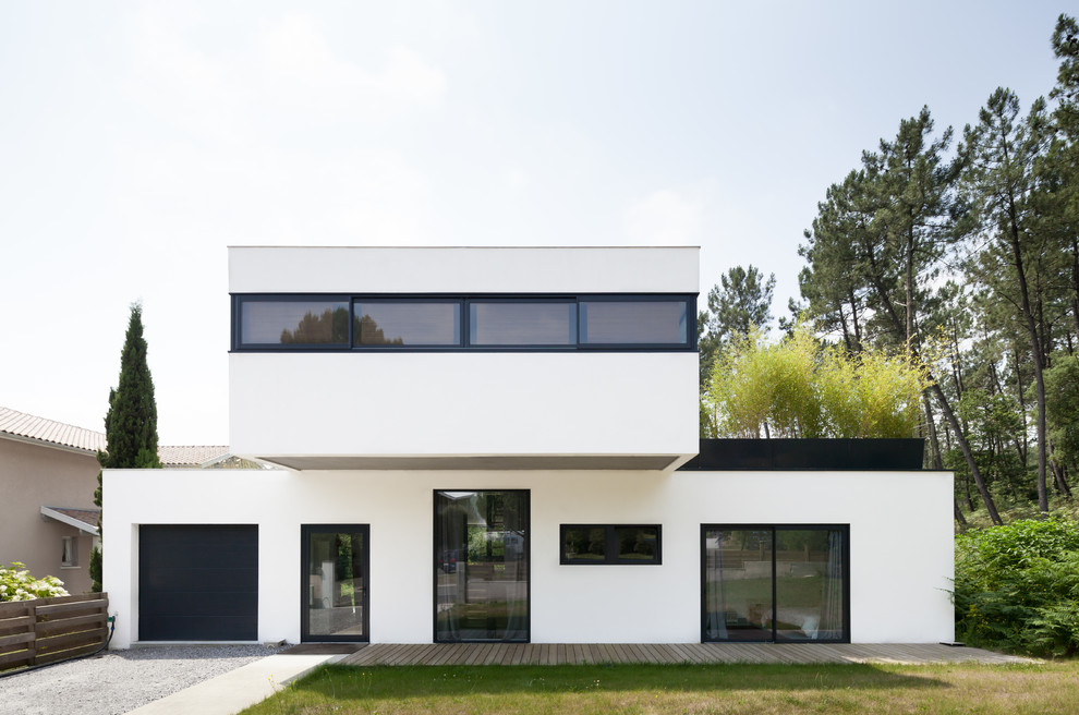 Inspiration för mellanstora moderna vita hus, med två våningar och platt tak