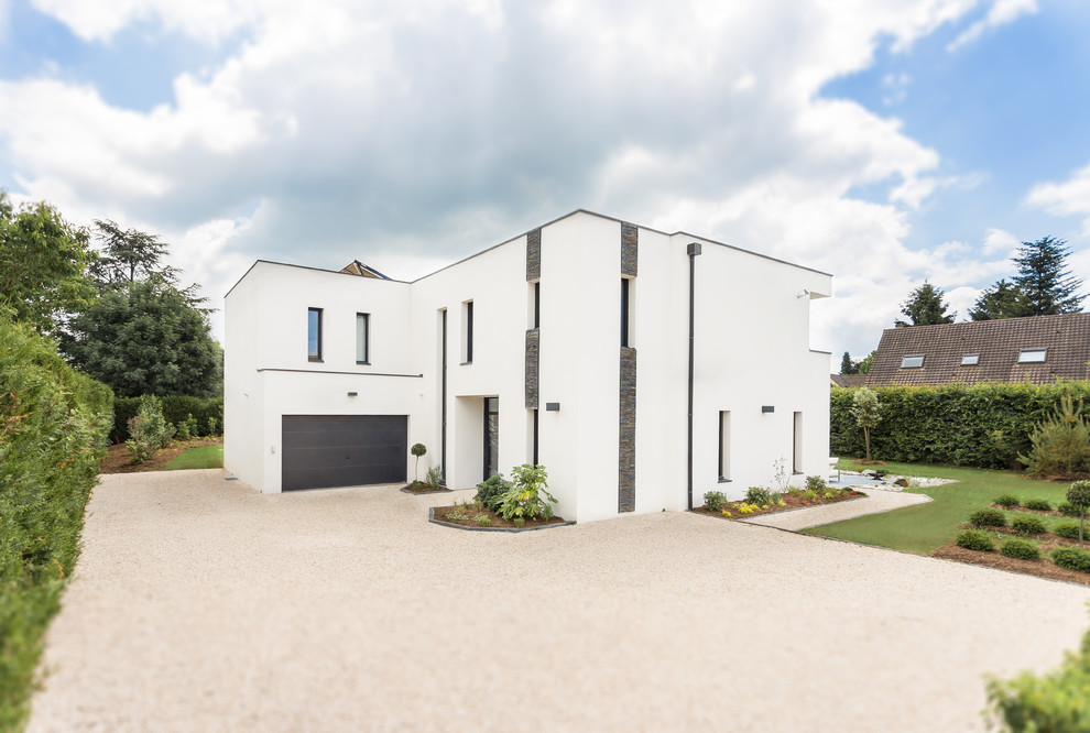 Inspiration pour une grande façade de maison blanche minimaliste en pierre à un étage avec un toit plat et un toit végétal.
