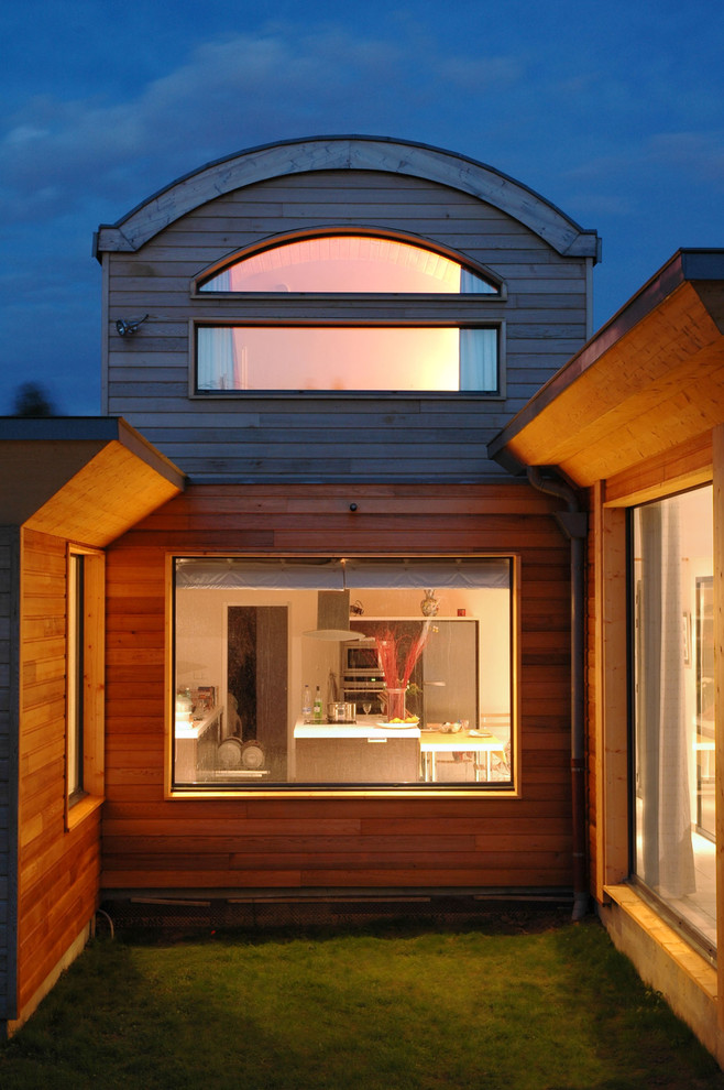 Exemple d'une très grande façade de maison marron tendance en bois à un étage.