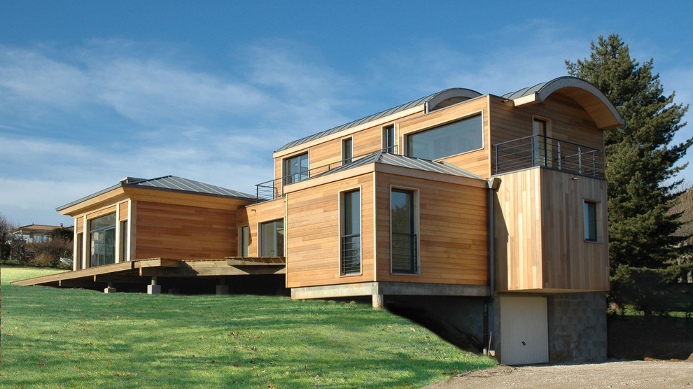 Idées déco pour une grande façade de maison beige contemporaine en bois à niveaux décalés avec un toit à quatre pans.