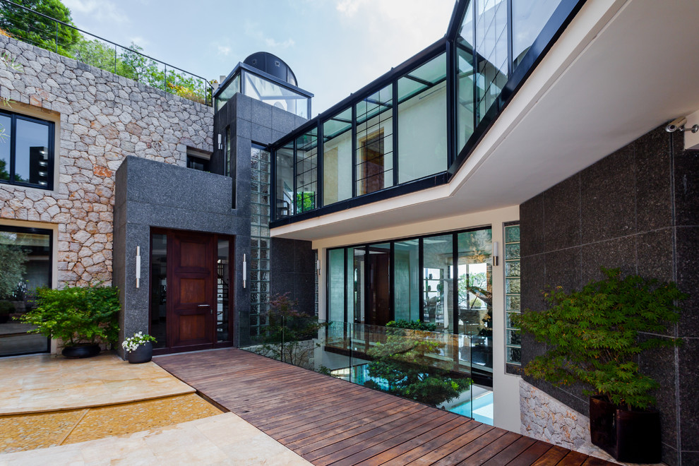 Example of a large trendy three-story stone flat roof design in Nice