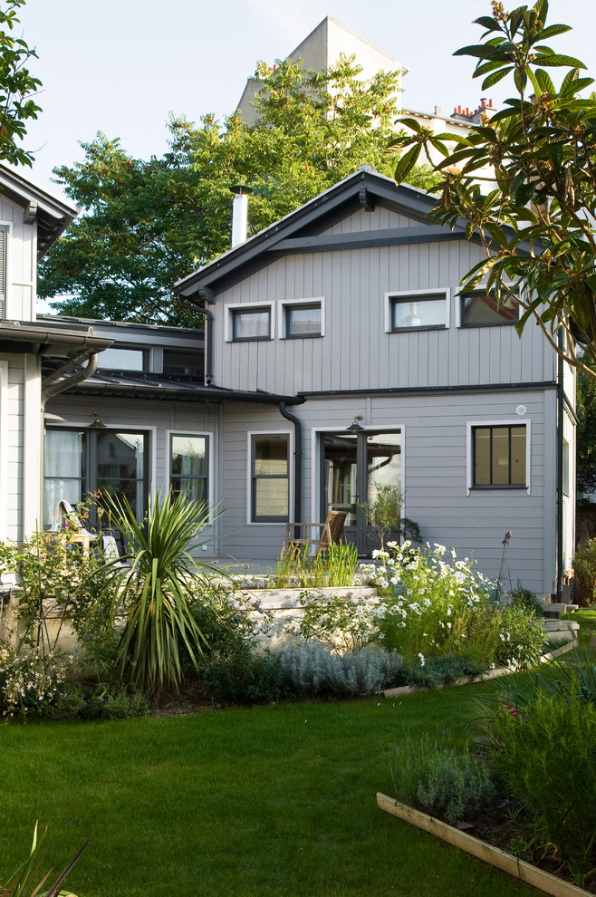 Cette image montre une façade de maison grise nordique à un étage et de taille moyenne avec un toit à deux pans.