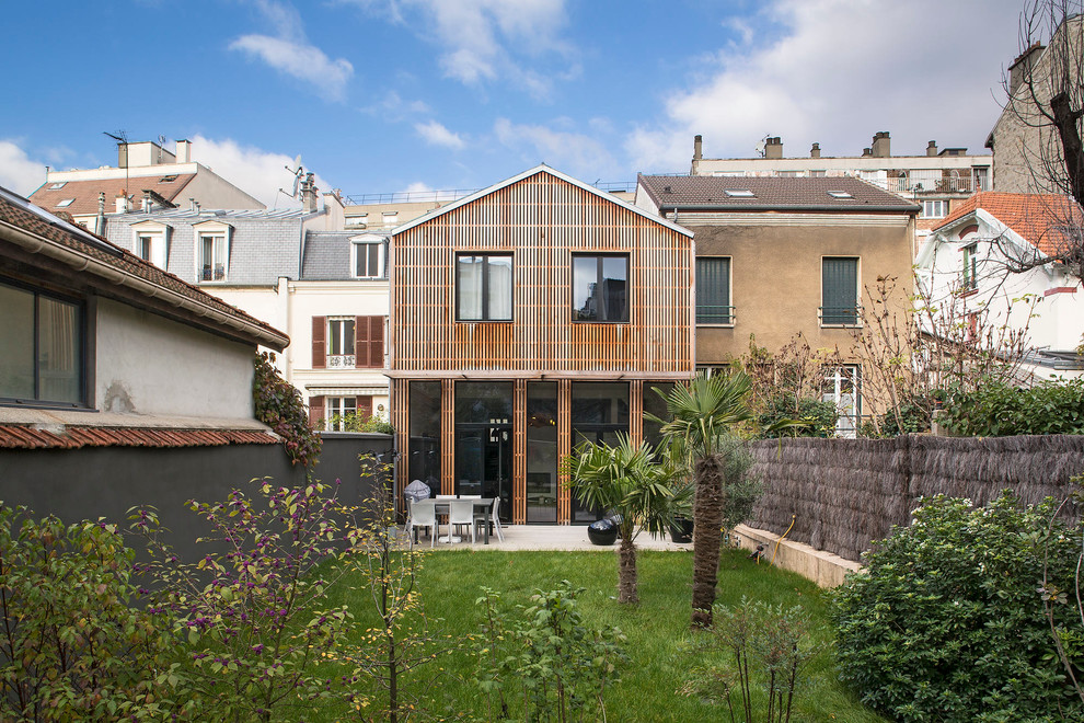 Cette image montre une façade de maison marron design en bois de taille moyenne et à un étage avec un toit à deux pans.