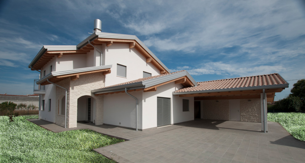 Réalisation d'une grande façade de maison beige minimaliste en pierre et bardage à clin à un étage avec un toit à deux pans, un toit en tuile et un toit rouge.