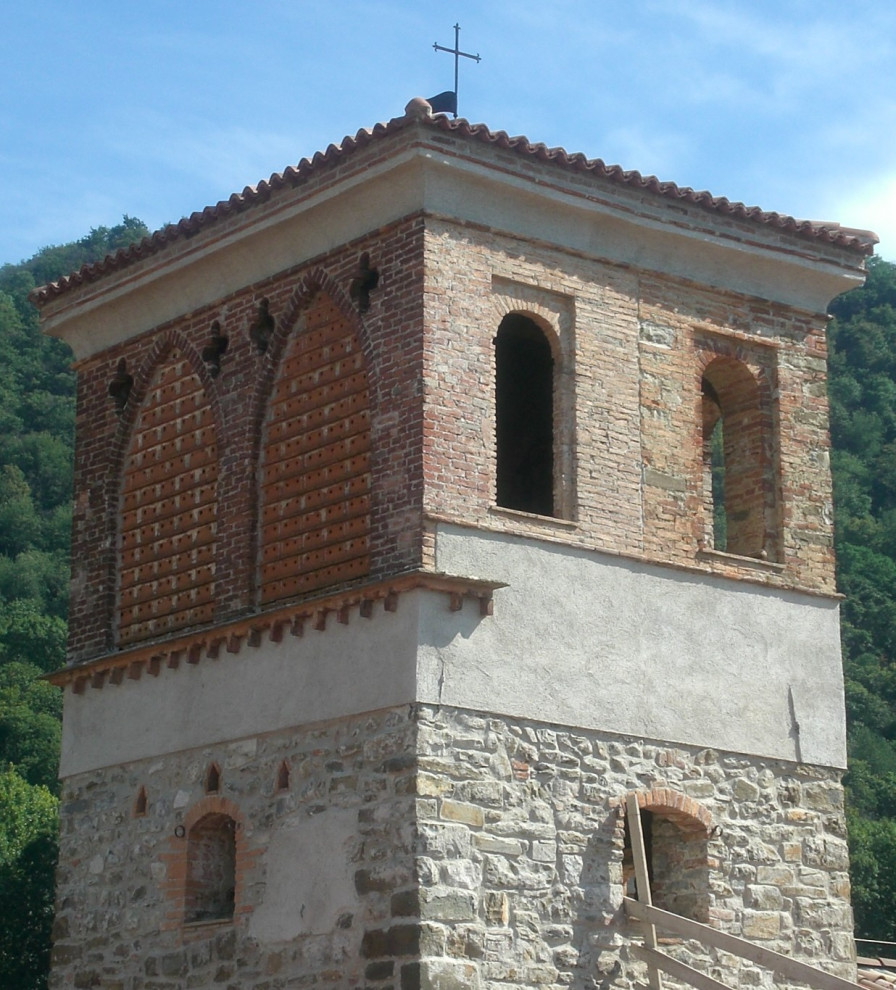 Immagine della facciata di una casa rustica con rivestimento in pietra e copertura in tegole