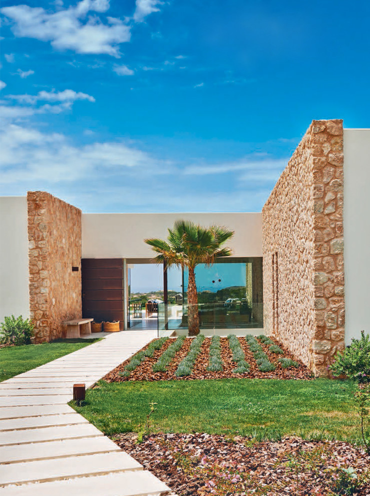Cette photo montre une façade de maison blanche méditerranéenne de taille moyenne et de plain-pied avec un revêtement mixte et un toit plat.