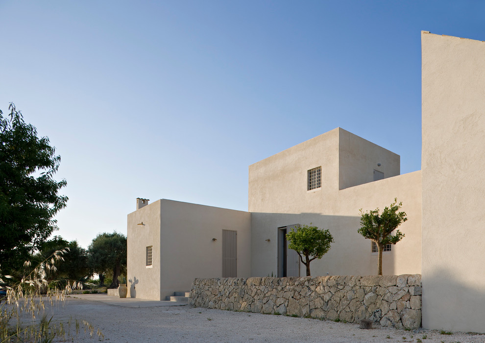 Idée de décoration pour une grande façade de maison blanche méditerranéenne en béton à un étage avec un toit plat.