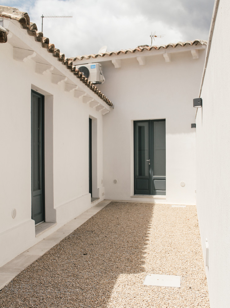 Foto della facciata di una casa bianca mediterranea a un piano di medie dimensioni con copertura in tegole