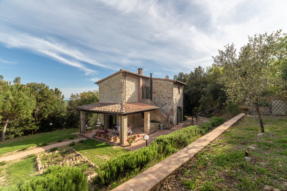 Beige country two floor detached house in Florence with stone cladding, a lean-to roof and a tiled roof.