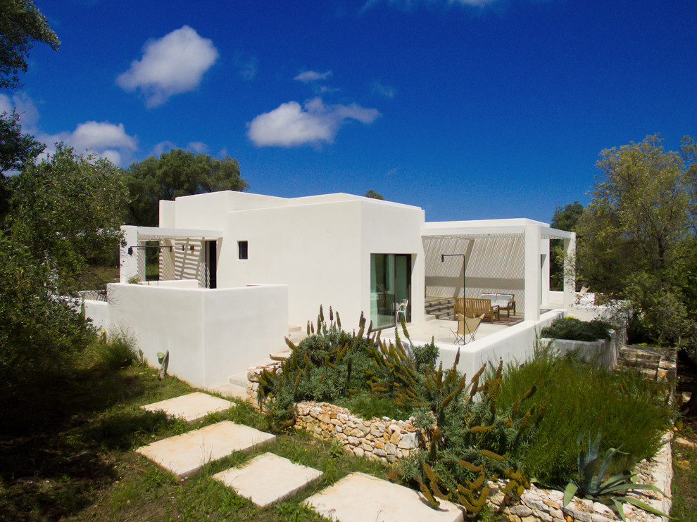 Example of a tuscan white one-story stucco exterior home design in Other