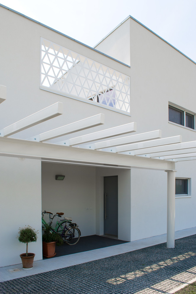 Modelo de fachada blanca actual de tamaño medio a niveles con revestimientos combinados y tejado de un solo tendido