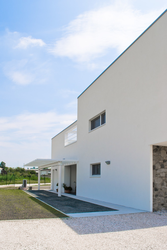 Mittelgroßes Modernes Haus mit weißer Fassadenfarbe und Pultdach in Sonstige