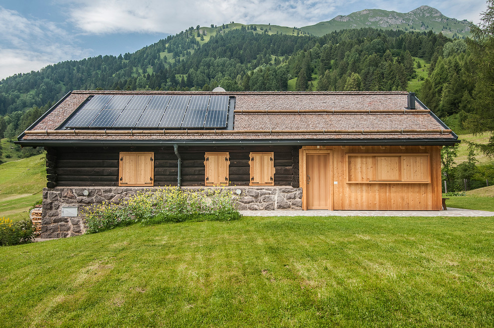 Diseño de fachada de casa rústica pequeña de una planta con revestimiento de madera, tejado a dos aguas y tejado de teja de madera