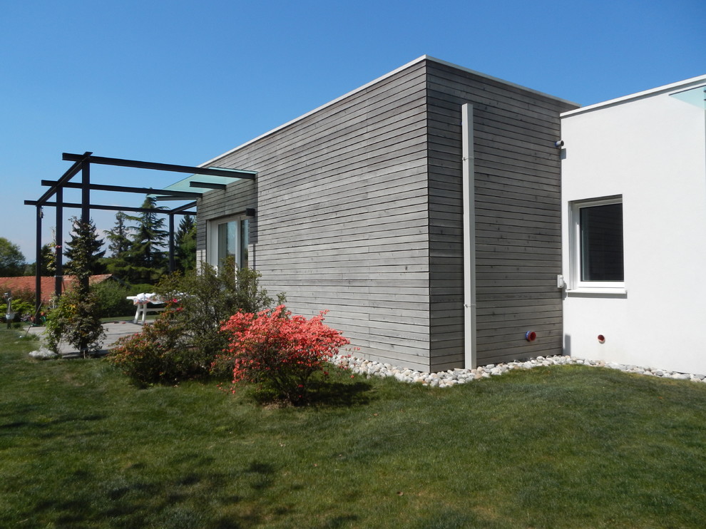 Immagine della villa bianca contemporanea a un piano di medie dimensioni con rivestimento in legno, tetto piano e copertura verde