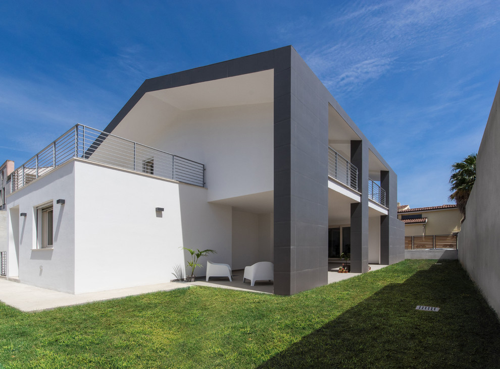 Large and gey contemporary two floor detached house in Cagliari with mixed cladding and a pitched roof.