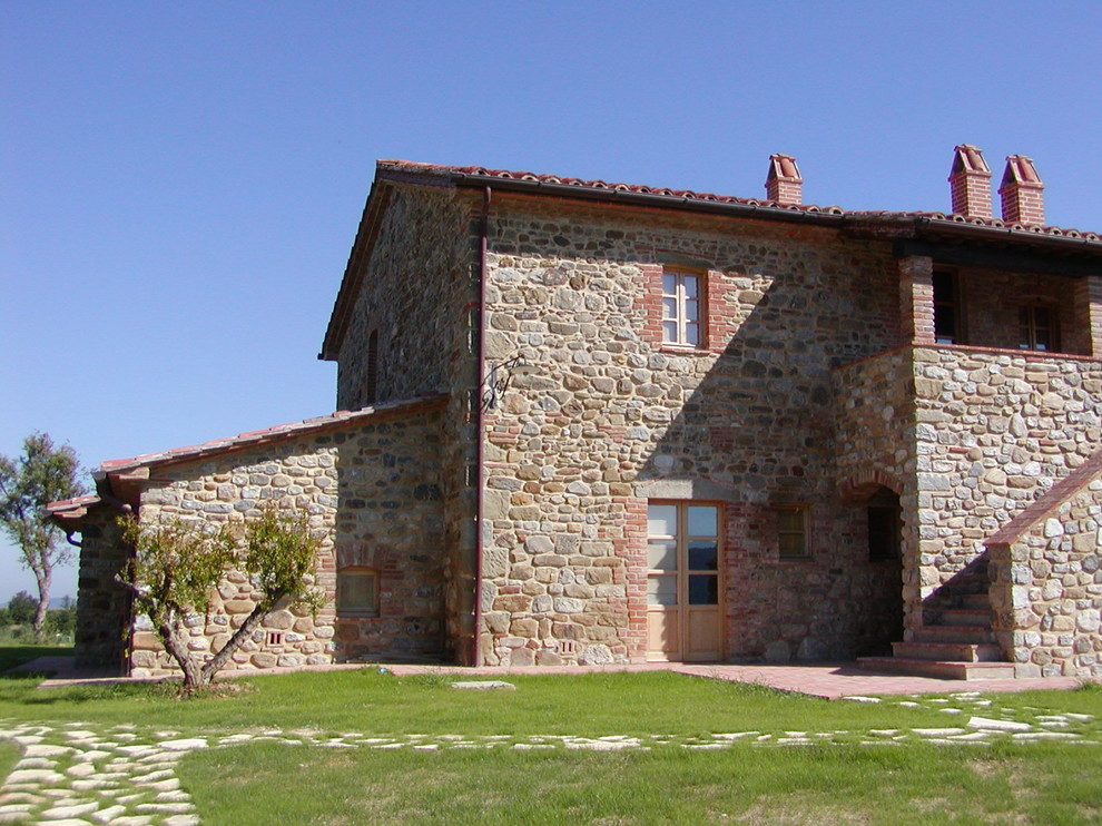 Modelo de fachada de casa beige campestre de tamaño medio de dos plantas con revestimiento de piedra, tejado a dos aguas y tejado de teja de barro