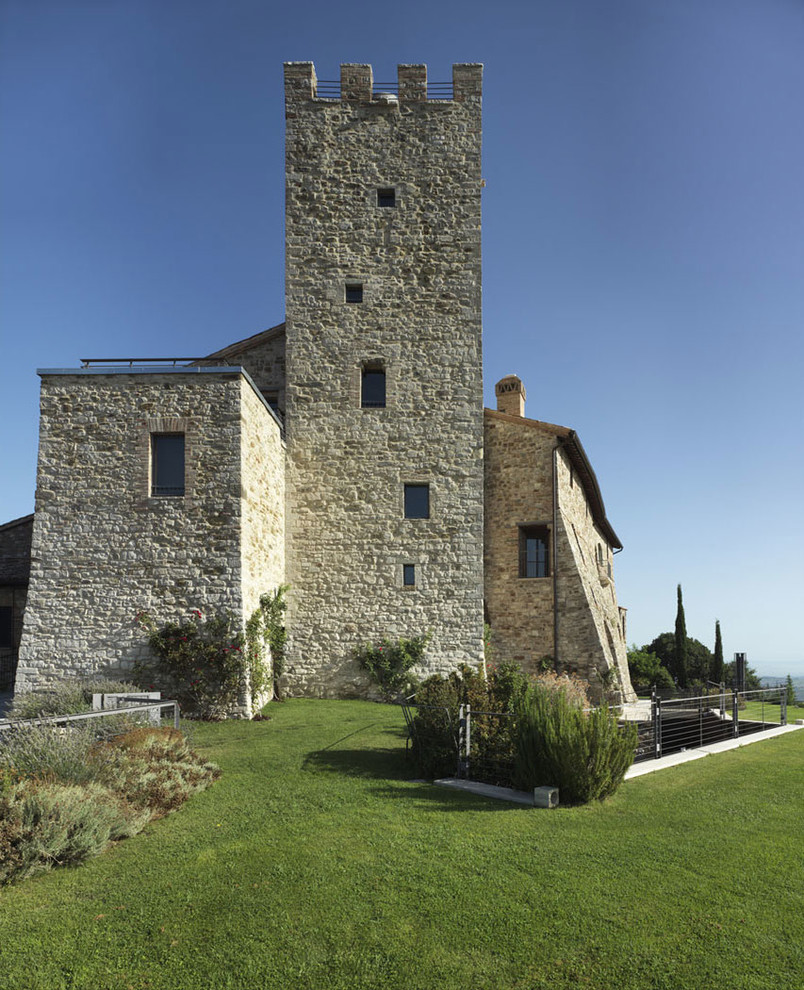 Ispirazione per la facciata di una casa ampia mediterranea con rivestimento in pietra