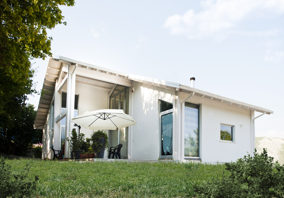 Ispirazione per la villa grande bianca contemporanea a due piani con rivestimento in stucco, tetto a capanna e copertura in tegole