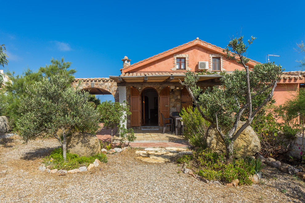 Cette photo montre une façade de maison rouge méditerranéenne de taille moyenne et à un étage avec un revêtement mixte et un toit à deux pans.