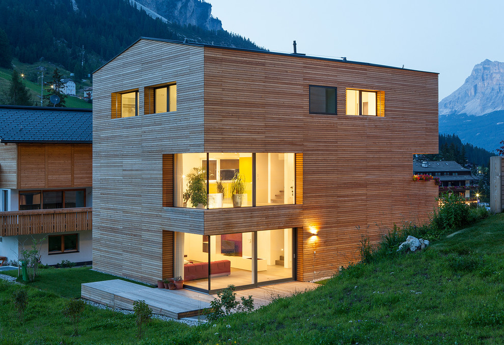 Cette image montre une façade de maison design en bois à deux étages et plus avec un toit à deux pans.