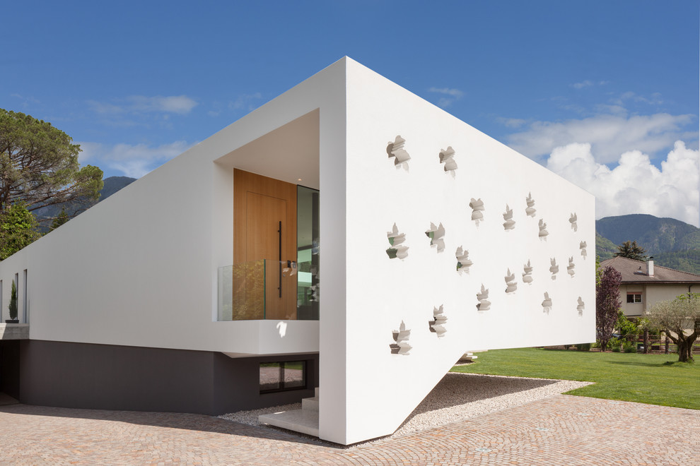 Идея дизайна: одноэтажный, белый частный загородный дом в стиле модернизм с плоской крышей и облицовкой из цементной штукатурки
