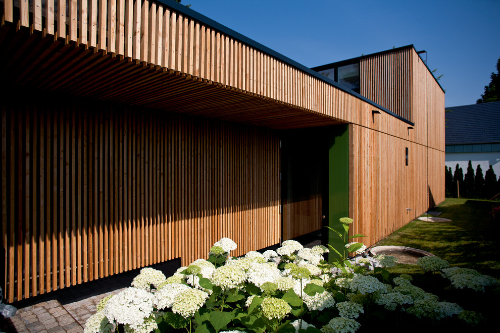 Mittelgroße, Zweistöckige Moderne Holzfassade Haus mit Flachdach und brauner Fassadenfarbe in Stuttgart