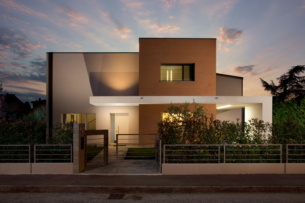 На фото: двухэтажный дом в стиле модернизм с плоской крышей с
