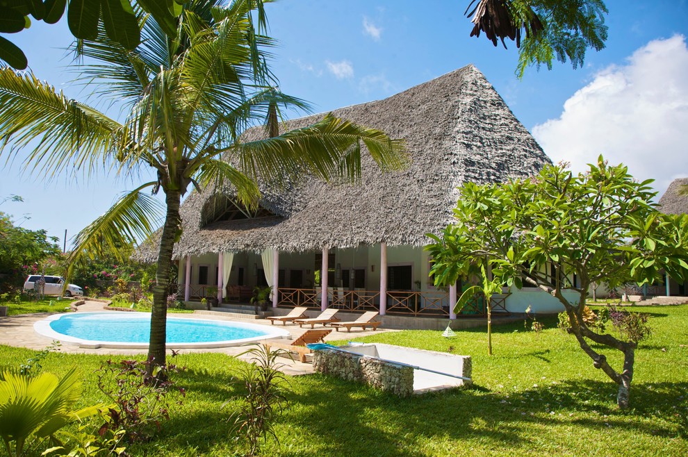 Idee per la facciata di una casa ampia tropicale a due piani con tetto a capanna