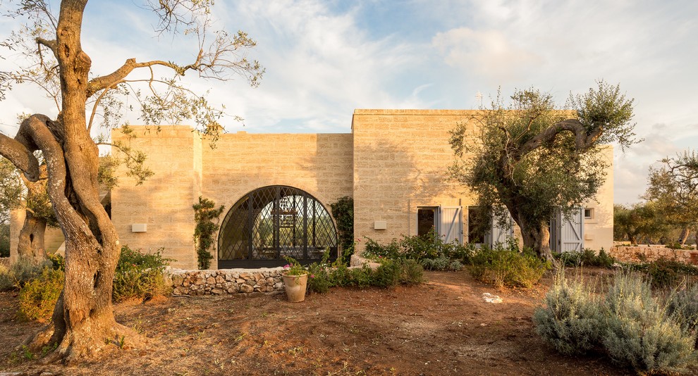 Ispirazione per la facciata di una casa beige mediterranea con rivestimento in pietra