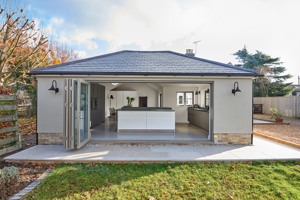 Idée de décoration pour une petite façade de maison grise design de plain-pied avec un revêtement mixte et un toit à quatre pans.