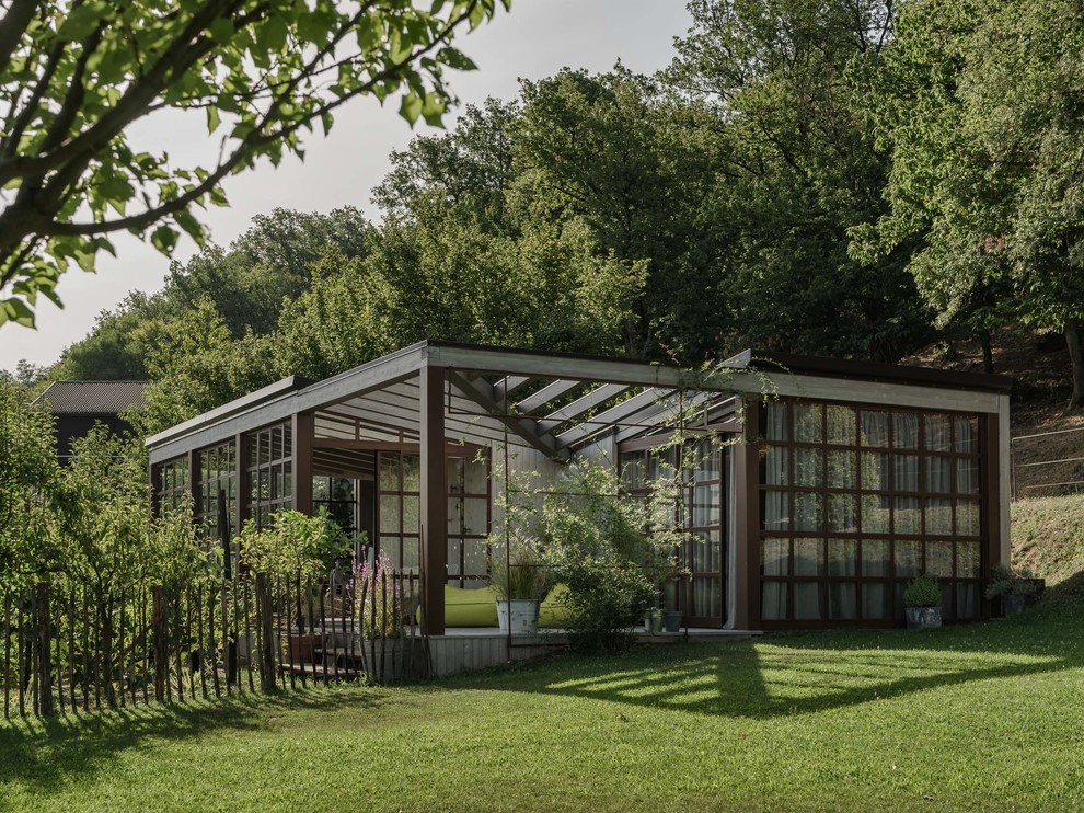 На фото: одноэтажный, деревянный, серый, маленький дом в современном стиле с плоской крышей для на участке и в саду