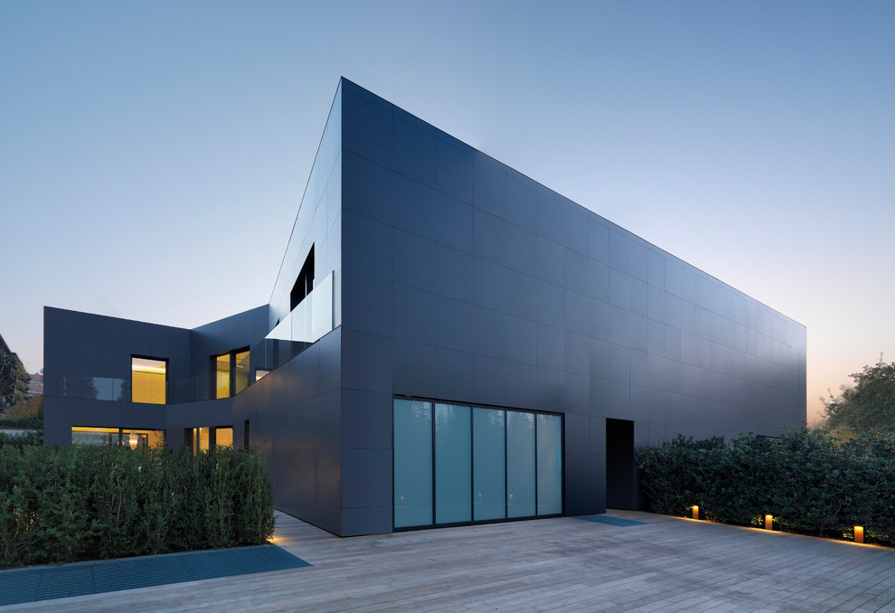 Photo of a large and gey contemporary two floor house exterior in Bologna with metal cladding and a flat roof.