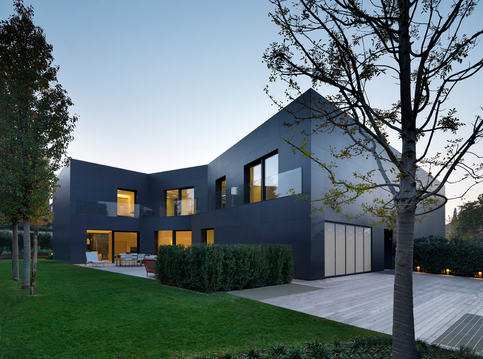 Photo of a large and gey contemporary two floor house exterior in Bologna with metal cladding and a flat roof.
