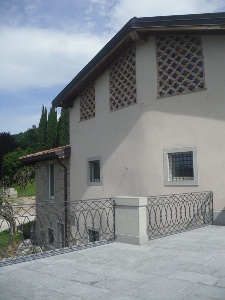 Foto de fachada de casa bifamiliar beige de estilo de casa de campo de tres plantas con revestimiento de piedra y tejado plano