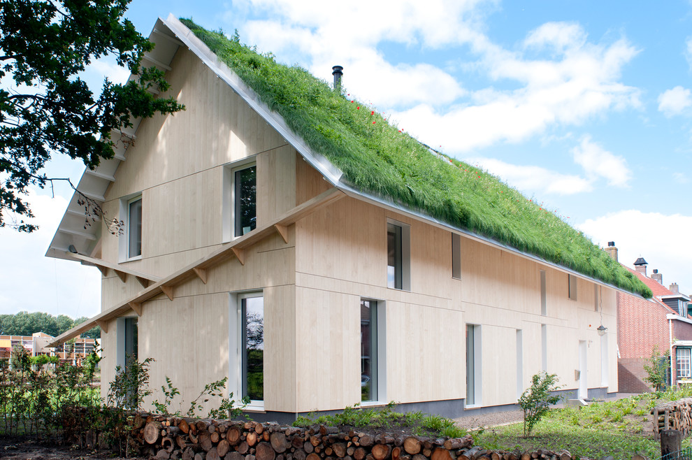Ispirazione per la villa beige country a due piani di medie dimensioni con rivestimento in legno, tetto a capanna e copertura verde