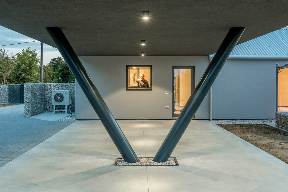 Foto della villa grigia contemporanea a due piani di medie dimensioni con rivestimento con lastre in cemento, falda a timpano e copertura in metallo o lamiera