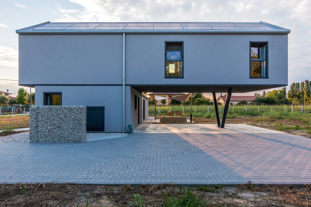Imagen de fachada de casa gris actual de tamaño medio de dos plantas con revestimiento de aglomerado de cemento, tejado a la holandesa y tejado de metal
