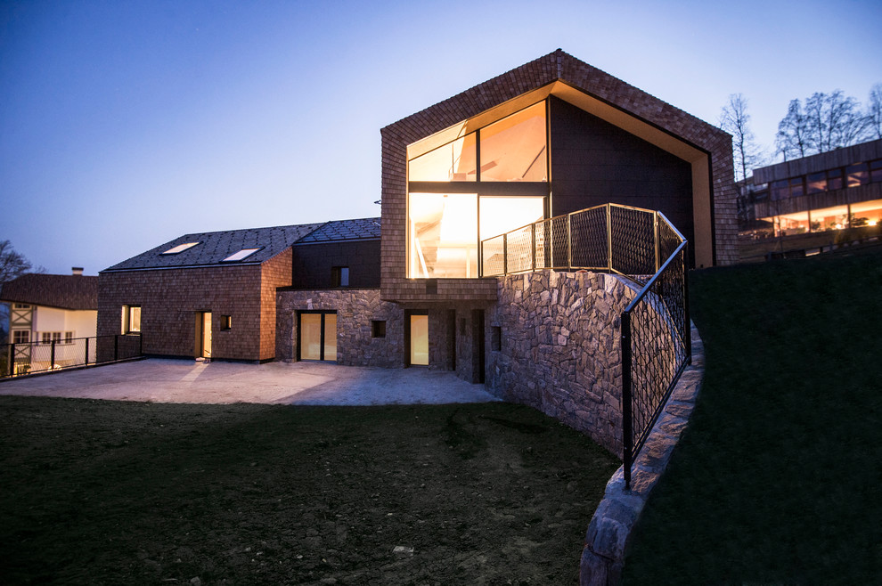 Foto della facciata di una casa contemporanea in pietra e intonaco